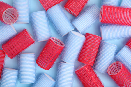 Hair curlers on turquoise background, flat lay. Styling toolの写真素材