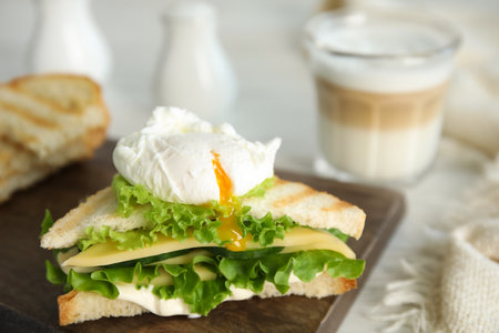 Delicious sandwich with vegetables and poached egg on board, closeupの写真素材