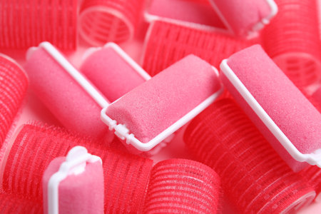 Different hair curlers on pink background, closeup. Styling toolの写真素材