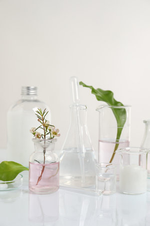 Natural ingredients and laboratory glassware for organic cosmetic product on white tableの写真素材