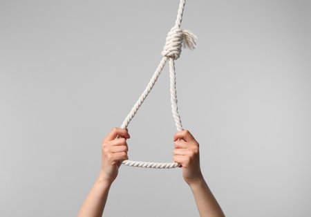 Woman holding rope noose on light gray background, closeupの写真素材