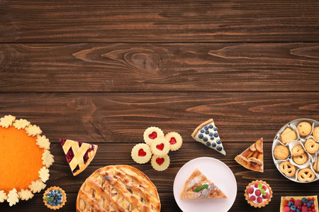 Flat lay composition with different delicious pies on wooden table. Space for textの写真素材