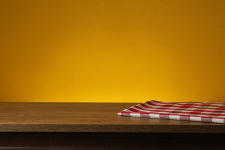 Red checkered textile napkin on wooden table. Space for textの写真素材