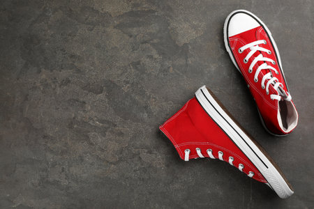 Pair of red sneakers on gray stone table, flat lay. Space for textの写真素材