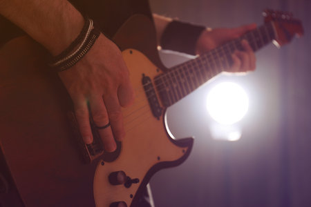 Man playing electric guitar on stage, closeup. rock musicの写真素材