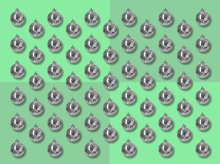 Many shiny disco balls on green background, flat lay