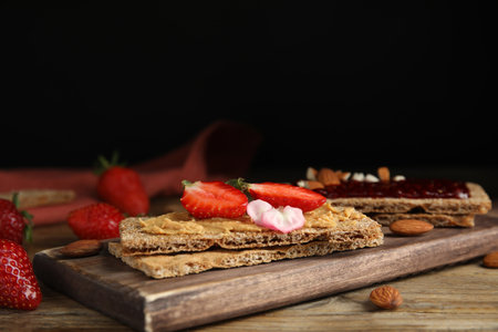 Fresh rye crispbreads with different toppings on wooden table. Space for textの写真素材