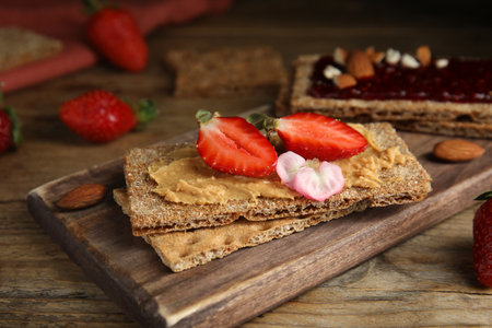 Fresh rye crispbreads with different toppings on wooden table, closeupの写真素材