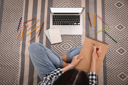 Woman drawing picture at online art lesson indoors, top view. Distant learningの写真素材