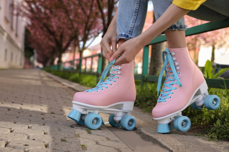 Young woman putting on roller skates outdoors, closeupの写真素材