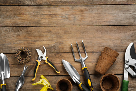 Flat lay composition with gardening tools on wooden background, space for textの写真素材