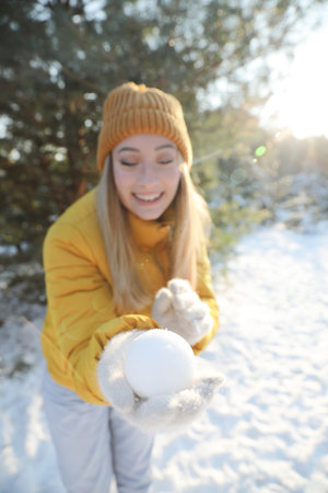 Woman with snowball outdoors, focus on hand