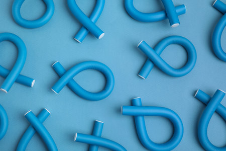 Curling rods on light blue background, flat lay. hair styling toolの写真素材