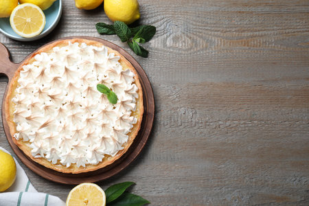 Flat lay composition with delicious lemon meringue pie on wooden table, space for textの写真素材