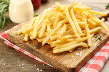 Delicious french fries served on wooden table, closeupの写真素材