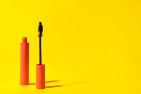 Mascara on yellow background, space for text. makeup productの写真素材