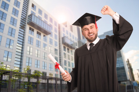 Happy student with graduation hat and diploma outdoorsの写真素材