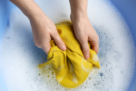 Top view of woman hand washing color clothing in suds, closeupの写真素材