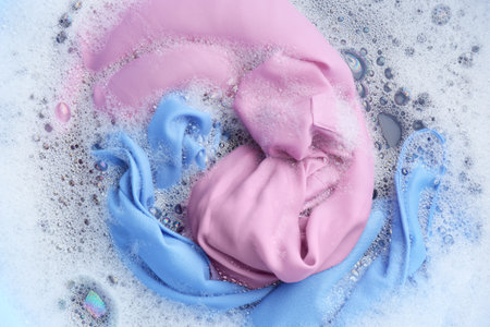 Color clothing in suds, top view. hand washing laundryの写真素材