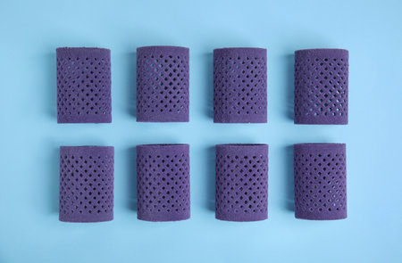 Hair curlers on turquoise background, flat lay. Styling toolの写真素材