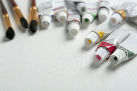 Brushes and paints on blank canvas, closeup. Space for textの写真素材