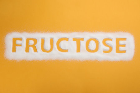 Word Fructose made of sugar on orange background, top viewの写真素材