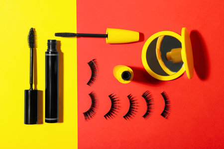 Different mascaras, fake eyelashes and mirror on color background, flat lay. makeup productの写真素材