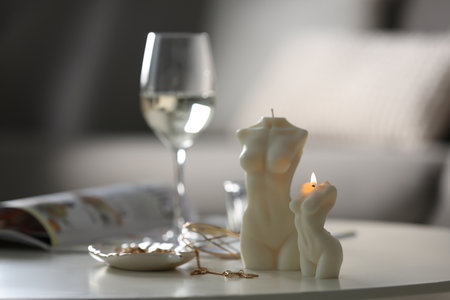 Beautiful body shaped candles and jewelry on white table indoors, space for textの写真素材