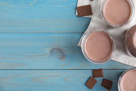Delicious chocolate milk on light blue wooden table, flat lay. Space for textの写真素材