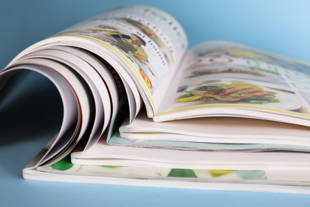 Stack of magazines on light blue background, closeupの写真素材