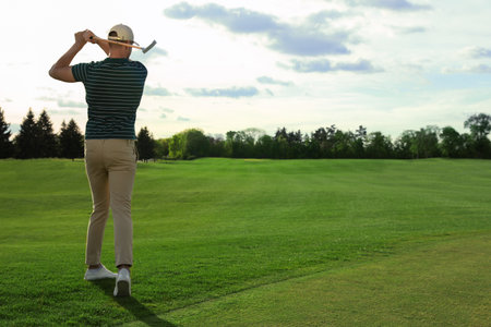 Man playing golf on green course, back view. Space for textの写真素材