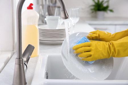 Woman washing plate in modern kitchen, closeupの写真素材