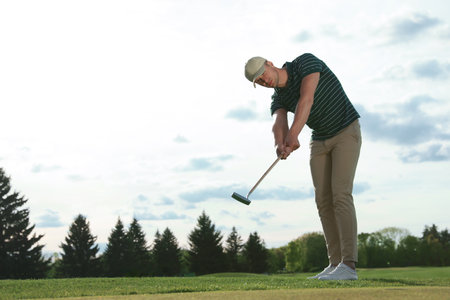 Man playing golf on green course, space for textの写真素材