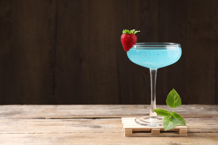 Refreshing light blue cocktail on wooden table, space for textの写真素材