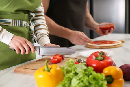 Couple making pizza in the kitchen, closeup. Cooking togetherの写真素材