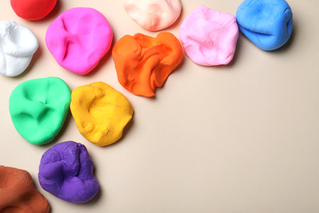 Colorful plastic on beige background, flat lay. Space for textの写真素材