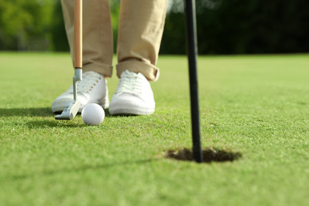 Person playing golf on green course, closeupの写真素材