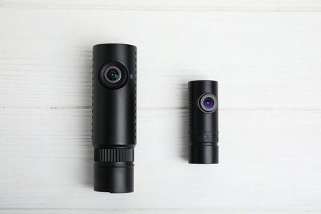 Black modern car cameras on white wooden table, flat layの写真素材