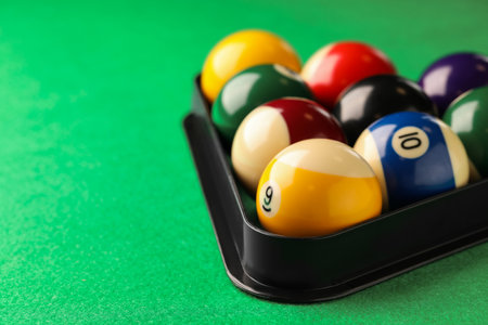 Billiard balls in triangle rack on green table, closeup. Space for textの写真素材