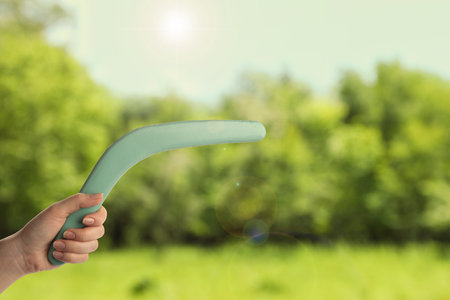 Woman holding boomerang outdoors, closeup. Space for textの写真素材