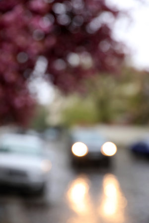 Blurred view of beautiful blossoming tree and car on city street. bokeh effectの写真素材