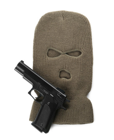 Beige knitted balaclava and pistol on white background, top viewの写真素材
