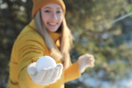 Woman with snowball outdoors, focus on hand. Space for textの写真素材