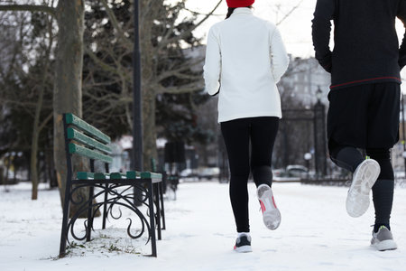 People running in winter park, closeup. outdoor sports exercisesの写真素材