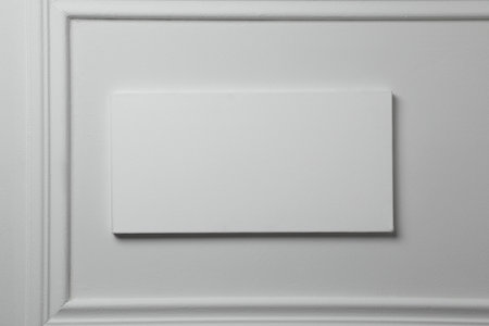 Blank canvas hanging on white wall, space for text