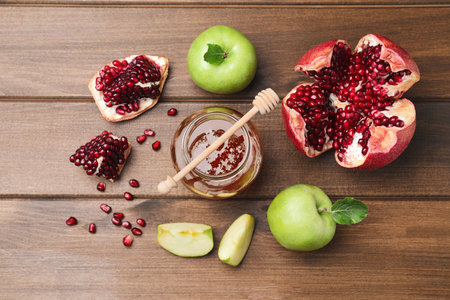 Honey, pomegranate and apples on wooden table, flat lay. Rosh Hashanah holidayの写真素材