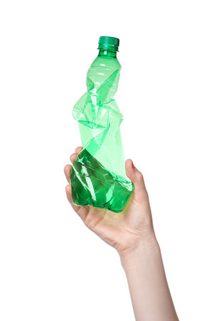 Woman holding crumpled plastic bottle on white background, closeupの写真素材