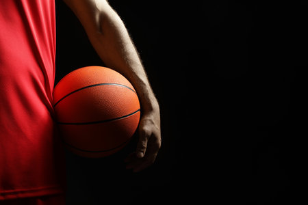Basketball player with ball on black background, closeup. Space for textの写真素材
