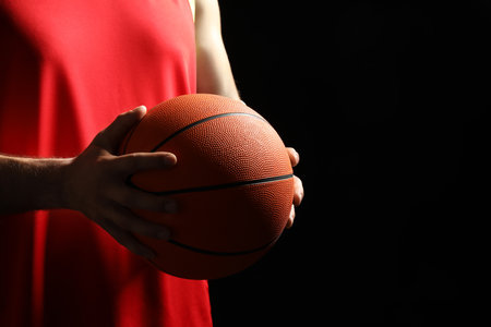 Basketball player with ball on black background, closeup. Space for textの写真素材