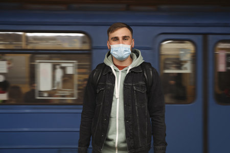 Young man in protective mask near subway train. public transportの写真素材